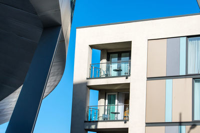 Low angle view of modern building against clear blue sky