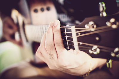 Cropped hands of man playing guitar