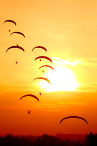 Kite flying in sky during sunset