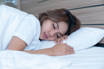 Midsection of woman sleeping on bed