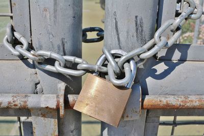 Close-up of padlock hanging on closed gate