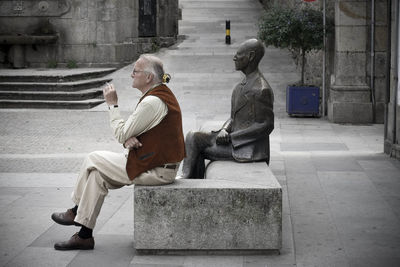 Rear view of man sitting on bench