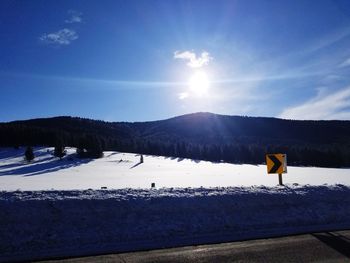 Scenic view of snowcapped mountains against blue sky on sunny day