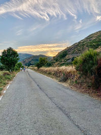 Road by mountain against sky