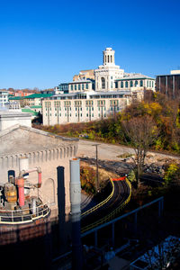 View of building by canal against clear blue sky