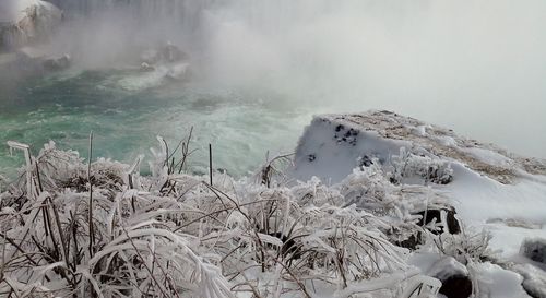 Panoramic view of snow covered land against sky