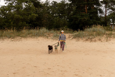 Rear view of woman walking on dirt road