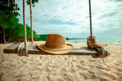 Lounge chairs on sand at beach against sky