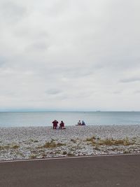 People on beach against sky