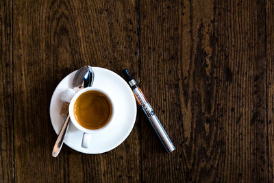 Directly above shot of coffee cup on wooden table