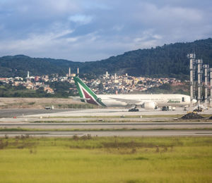 Airplane on runway against sky