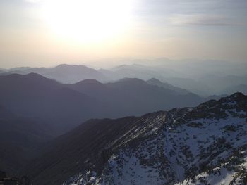 Scenic view of snow covered mountains against sky during sunset