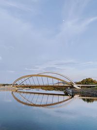 Arch bridge over river against sky