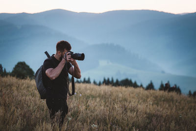 Man photographing on field