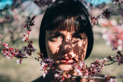 Woman in behind cherry blossom tree