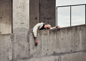 Side view of young man against wall