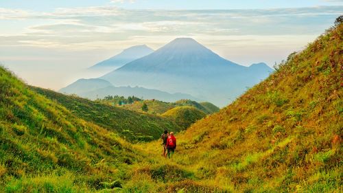 Rear view of man on mountain against sky