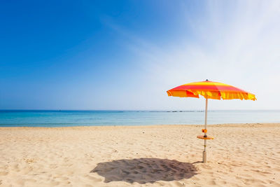 Umbrella on beach against sky