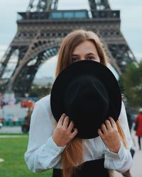 Close-up portrait of woman standing against building