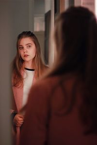 Portrait of woman standing in front of mirror