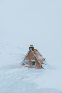 Built structure on snow covered land against clear sky