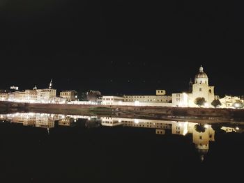 Reflection of buildings in lake at night