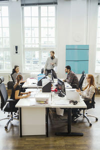 Business people at computer desks in creative office