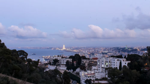 High angle view of townscape by sea against sky