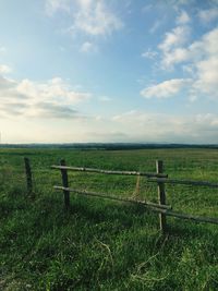 Fence on field against sky