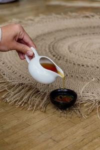 Cropped hand of woman holding coffee on table