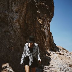 Rear view of hiker standing on rock formation