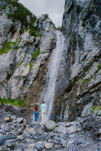 Rear view of people on rock against mountain