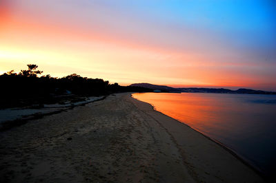 Scenic view of beach against sky during sunset