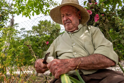 Portrait of senior man sitting against plants