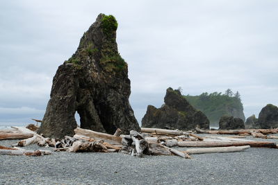 Rock formation by sea against sky