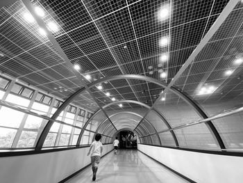 Rear view of people walking in illuminated modern building
