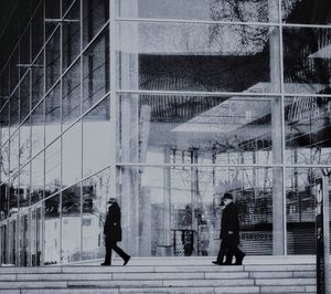 People walking on street by modern building