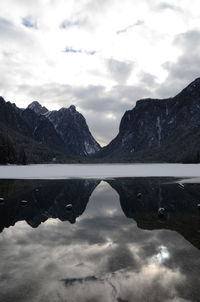 Scenic view of lake by mountains against sky