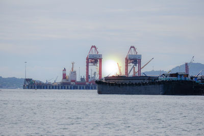 Commercial dock by sea against sky