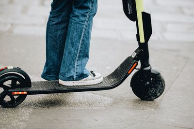 Low section of person with skateboard on street