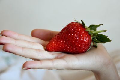 Close-up of hand holding strawberry