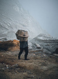 Rear view of man standing on rock