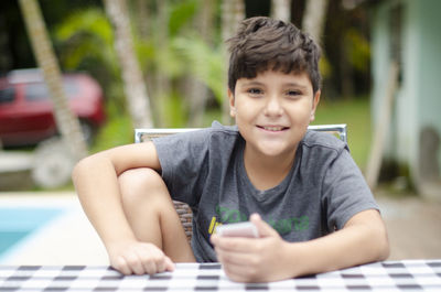 Portrait of boy sitting on table