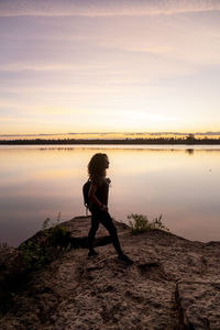 Traveler woman walking by the lake during sunset.