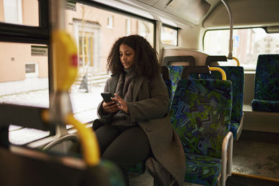 Woman in bus using cell phone