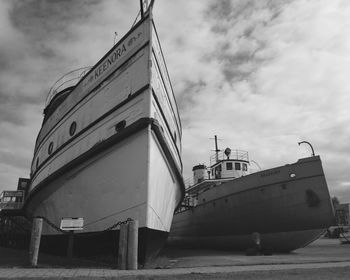 Low angle view of ship moored at harbor against sky