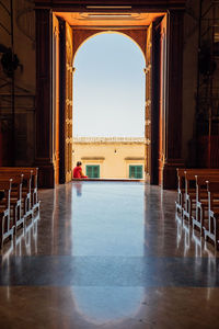 Empty chairs and tables in building against clear sky