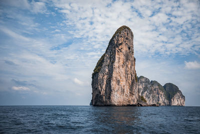 Rock formation in sea against sky