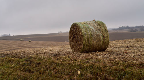 Hay bales on field against sky