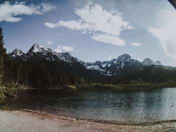 Scenic view of lake by mountains against sky